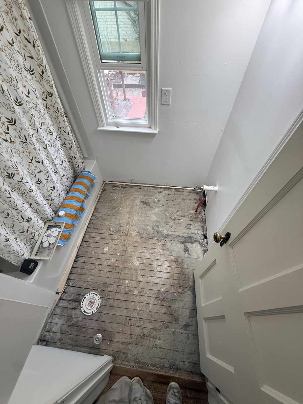 Bathroom before — gutted to subfloor